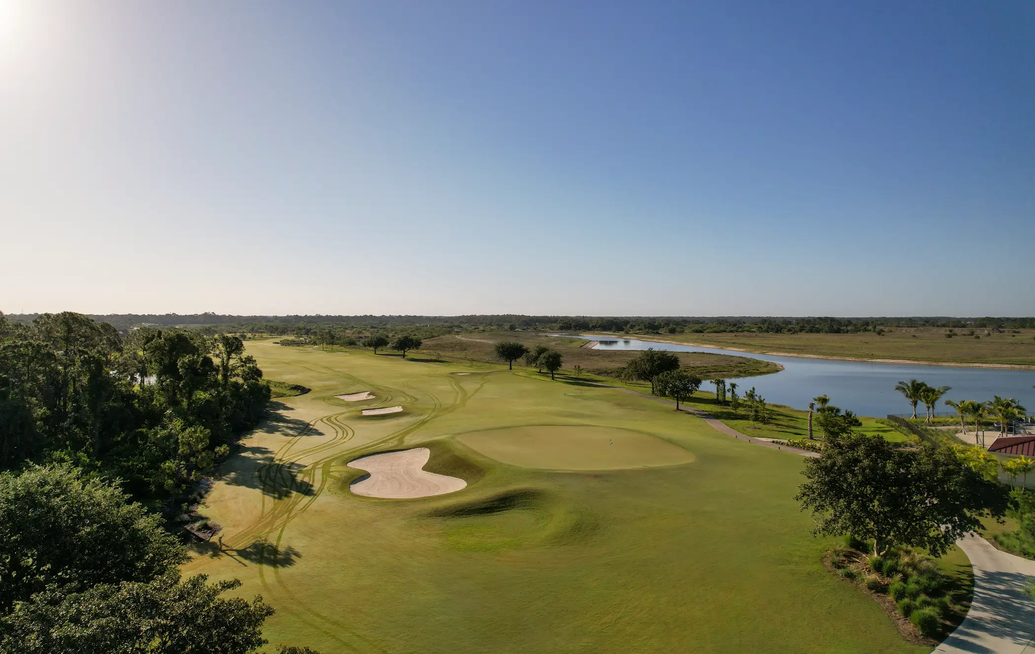 Drone aerial of the Davis Love III championship golf course winding through lakes at River Hall