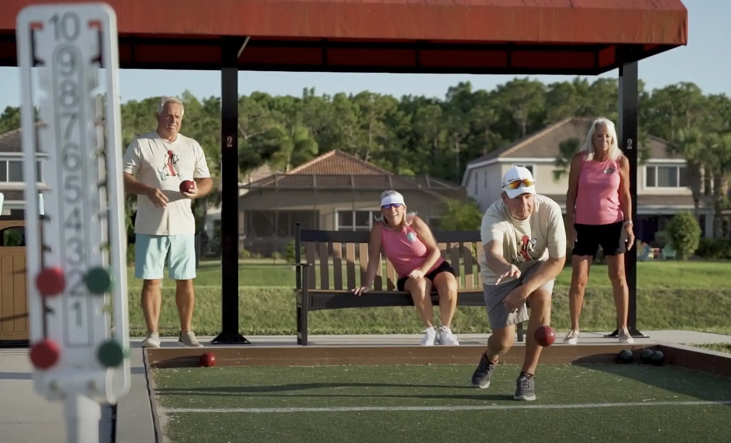 Neighbors laughing during a bocce match at the community courts