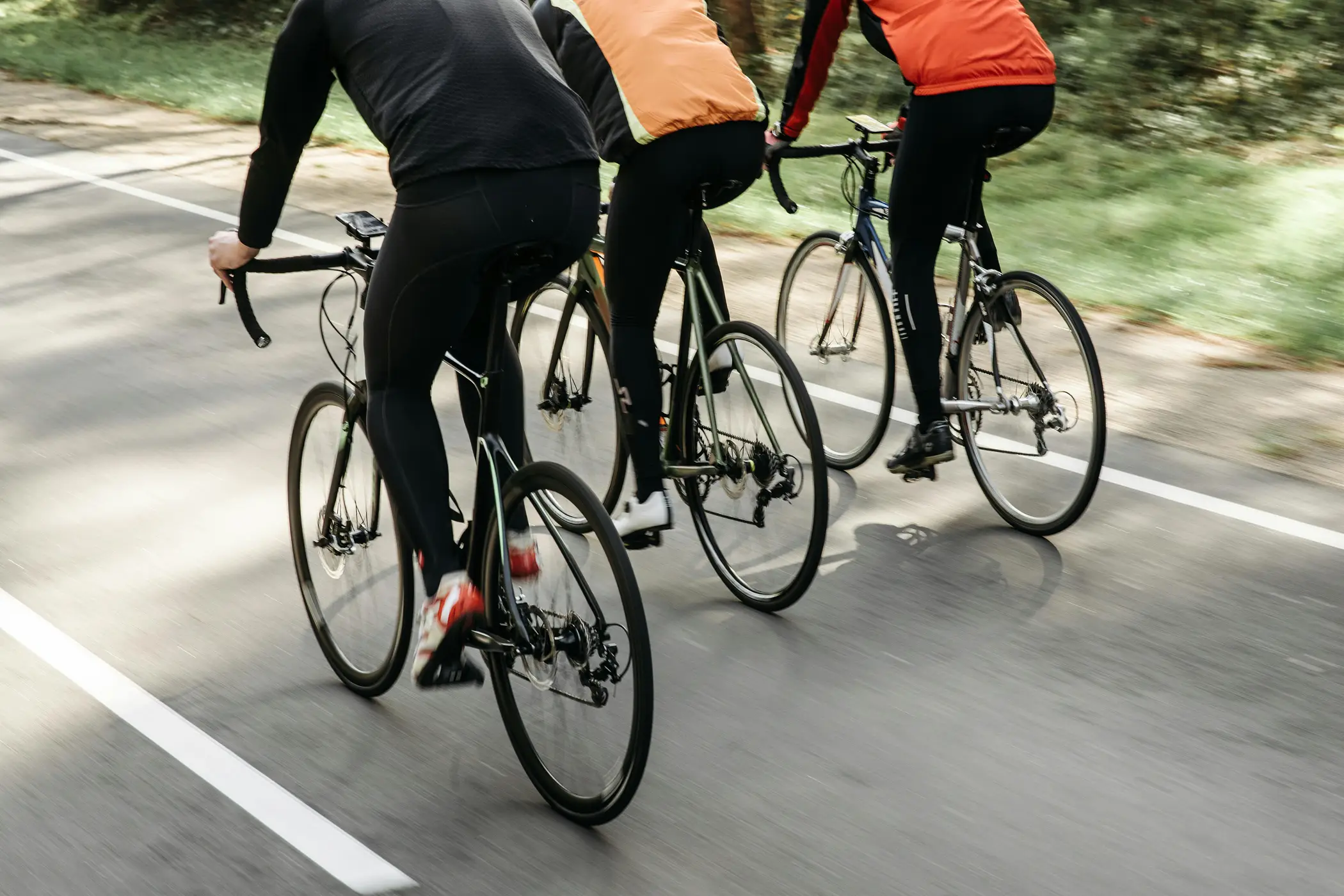 Three cyclists riding a shaded trail through Caloosahatchee Regional Park
