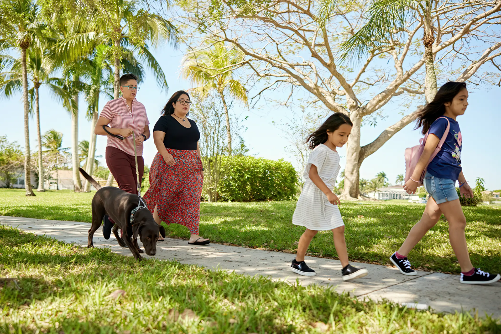 Family walking their dog along a lakeside community path