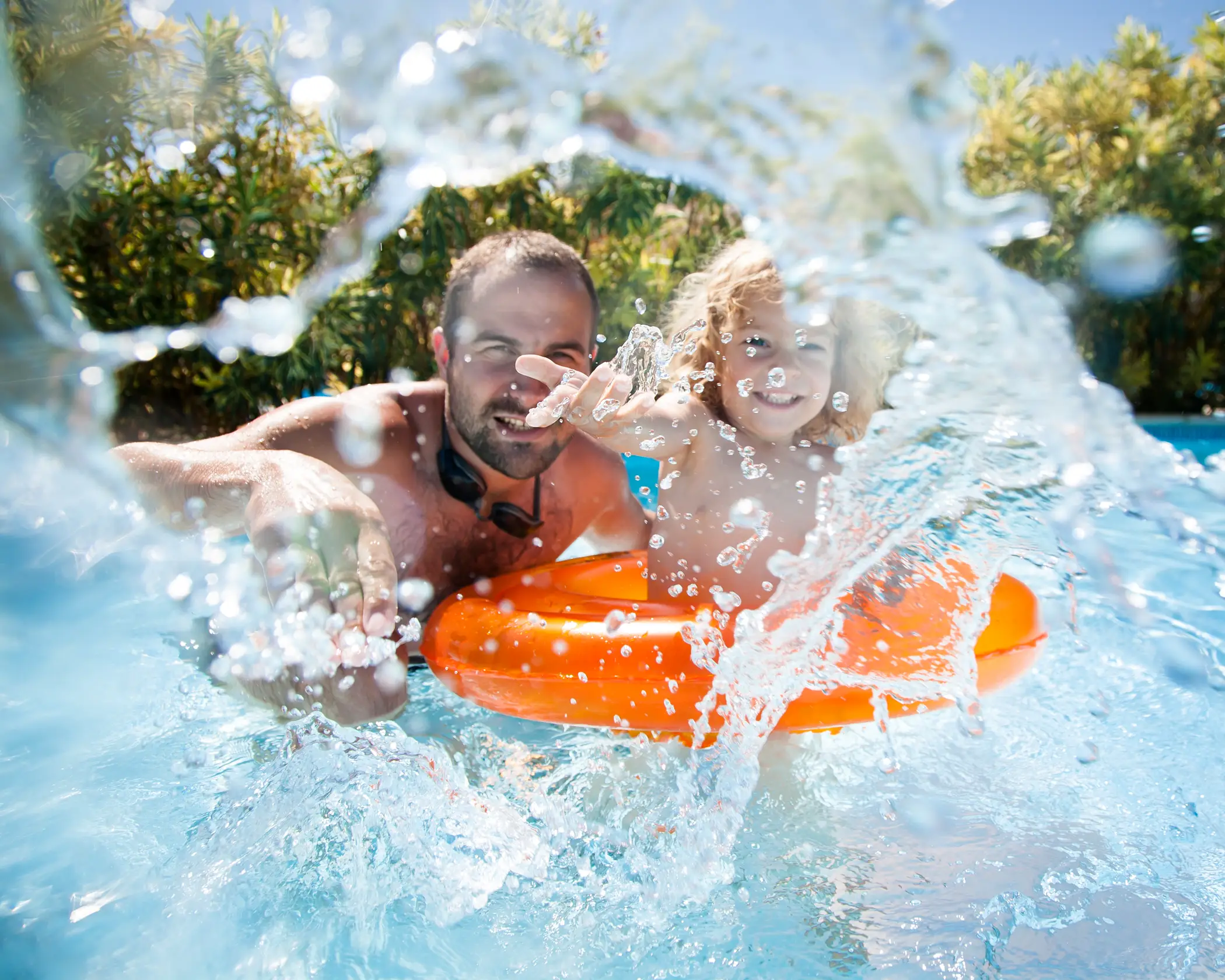 Father and son playing in the beach-entry lagoon pool