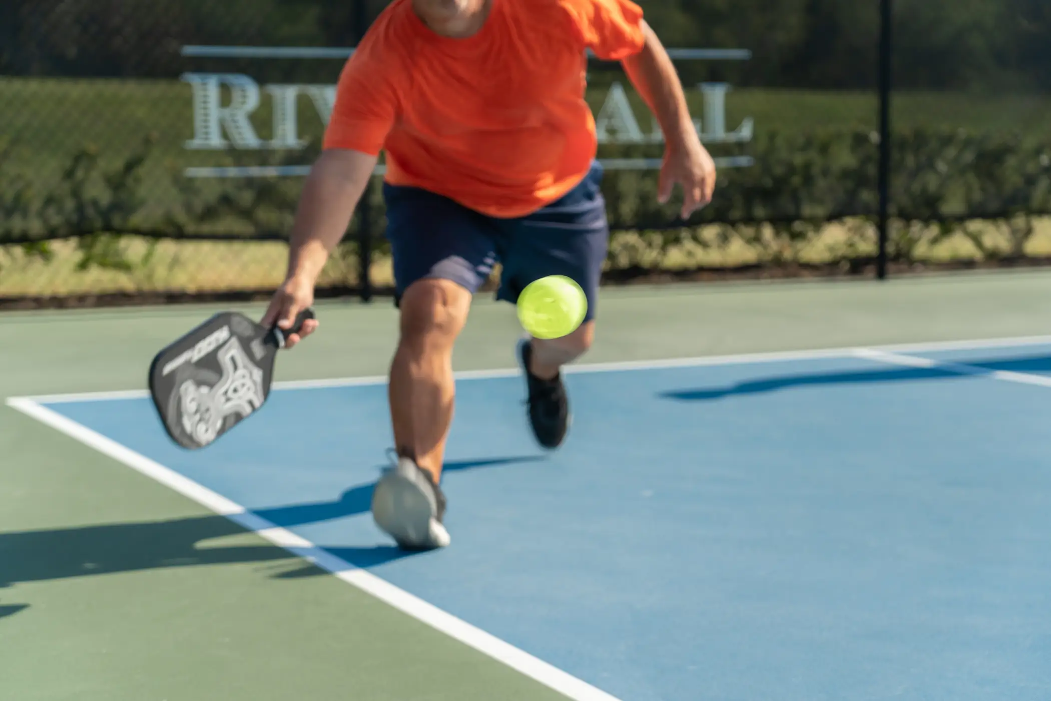 Players volleying at the net during a pickleball game at River Hall and Hampton Lakes