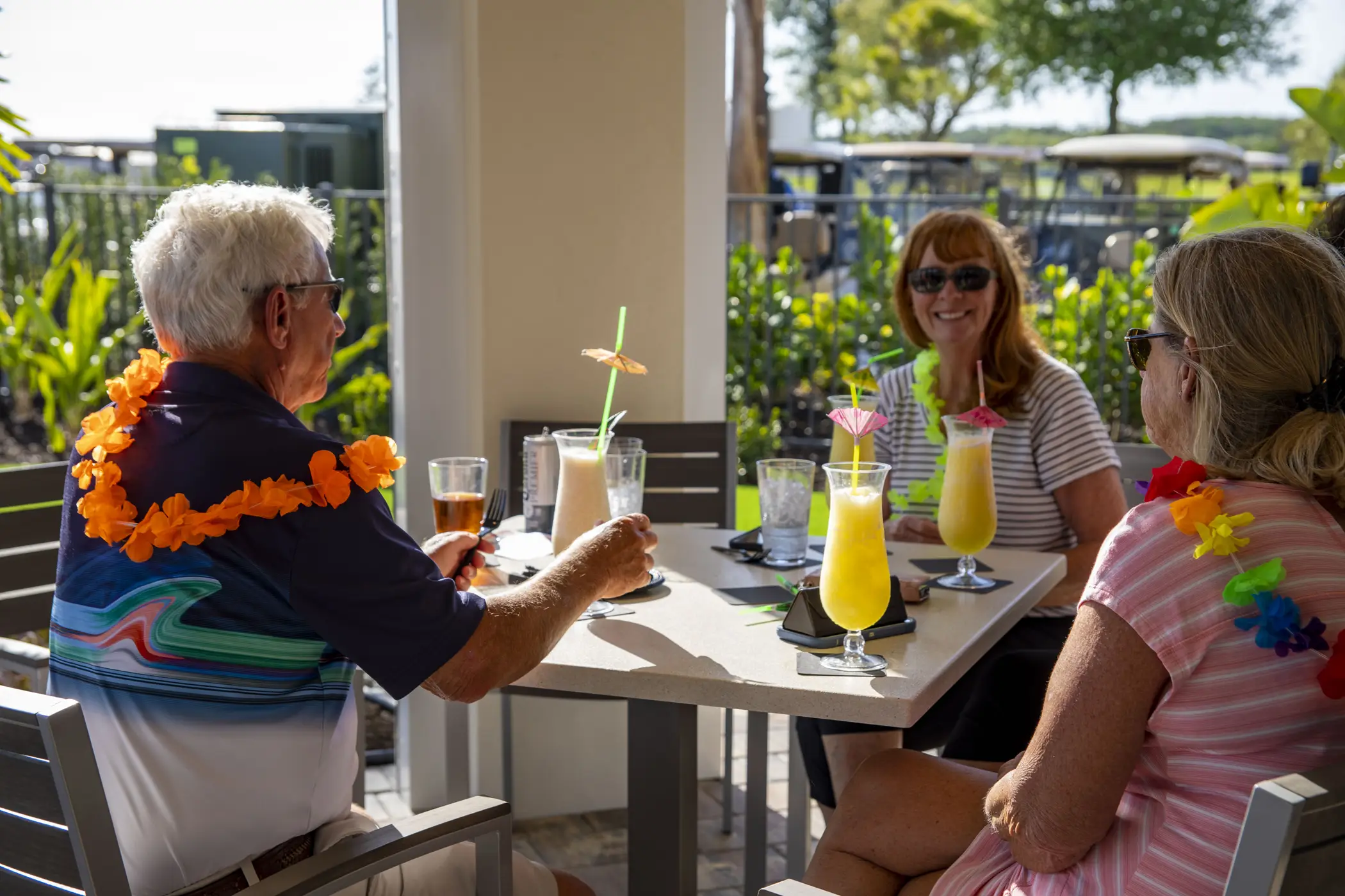 Friends sharing lunch at the poolside tiki bar inside River Hall Country Club